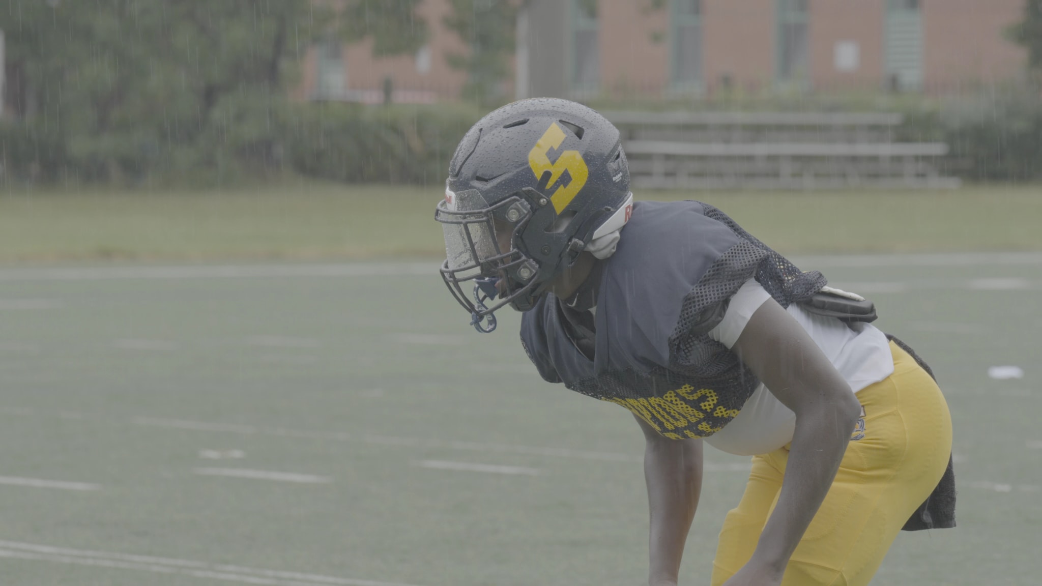 A football player in a helmet, flat camera log, before grading.